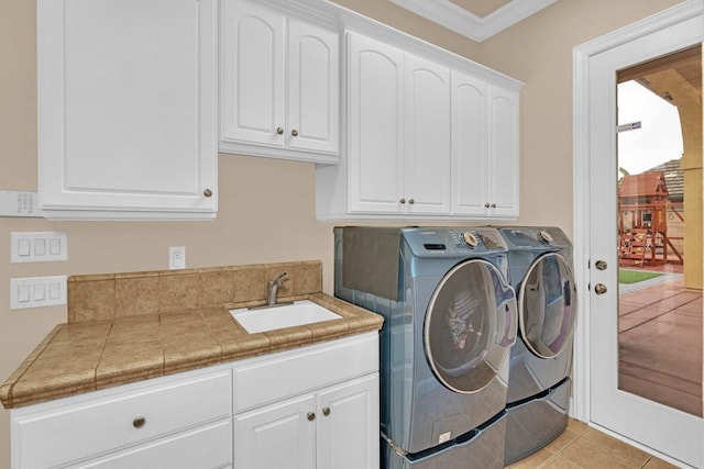 washroom with cabinets, ornamental molding, washer and clothes dryer, sink, and light tile patterned flooring