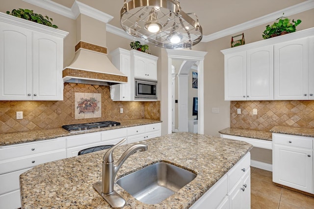 kitchen featuring light stone counters, sink, appliances with stainless steel finishes, and tasteful backsplash