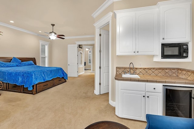 bedroom featuring wine cooler, ceiling fan, light colored carpet, and ornamental molding