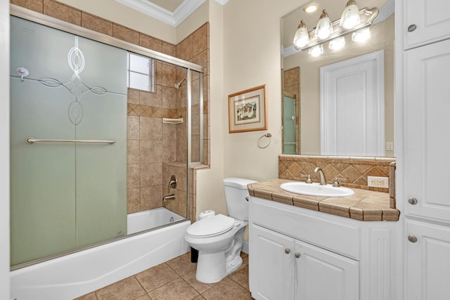 full bathroom with vanity, shower / bath combination with glass door, tile patterned flooring, toilet, and ornamental molding