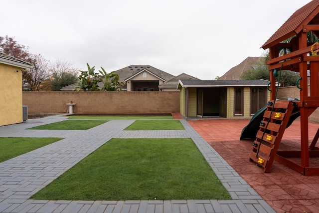 view of yard with a patio area, a playground, and an outbuilding