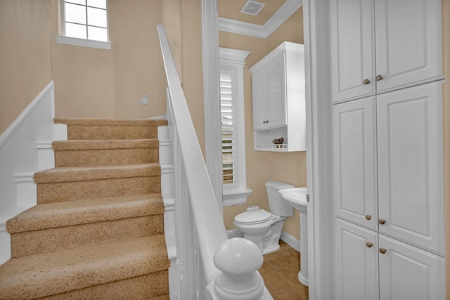 staircase with crown molding and tile patterned flooring