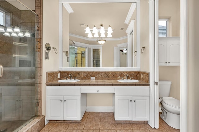 bathroom with toilet, vanity, an enclosed shower, and ornamental molding