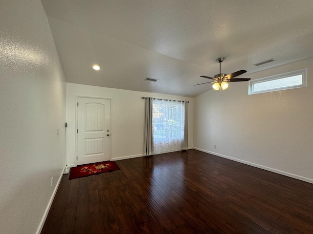 spare room with ceiling fan, dark wood-type flooring, and vaulted ceiling