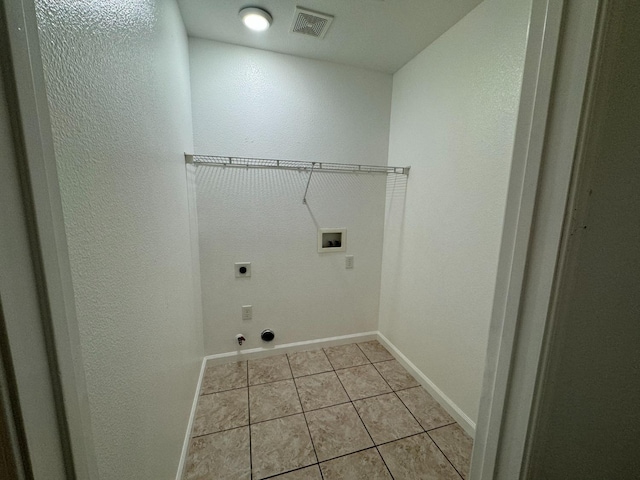 clothes washing area featuring gas dryer hookup, light tile patterned floors, washer hookup, and hookup for an electric dryer