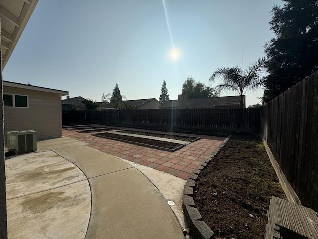 view of yard with central air condition unit and a patio