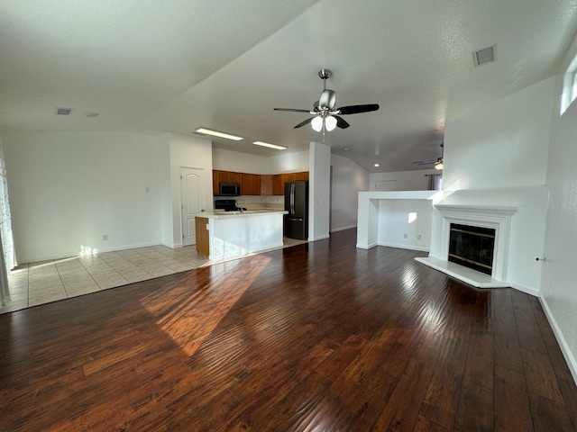 unfurnished living room with a textured ceiling, light hardwood / wood-style flooring, ceiling fan, and lofted ceiling