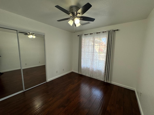 unfurnished bedroom featuring a closet, ceiling fan, and dark hardwood / wood-style floors