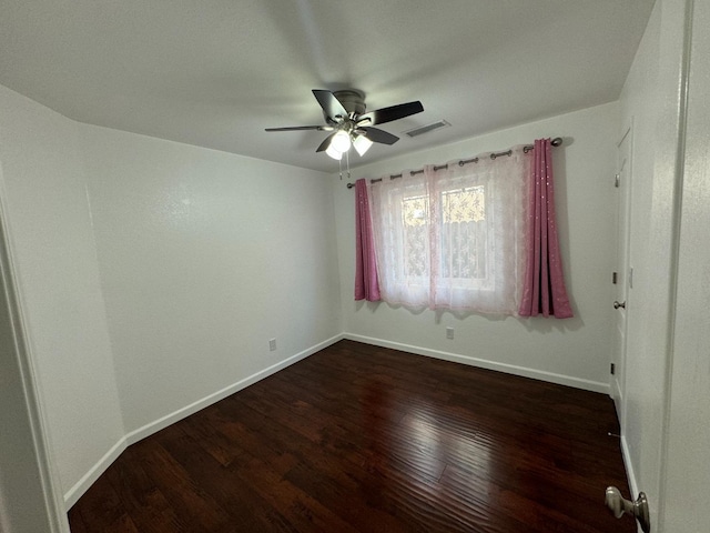 spare room featuring dark hardwood / wood-style flooring and ceiling fan