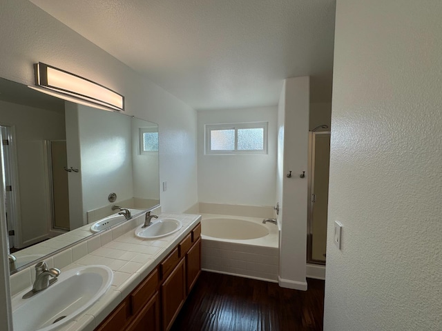 bathroom with hardwood / wood-style floors, vanity, and independent shower and bath