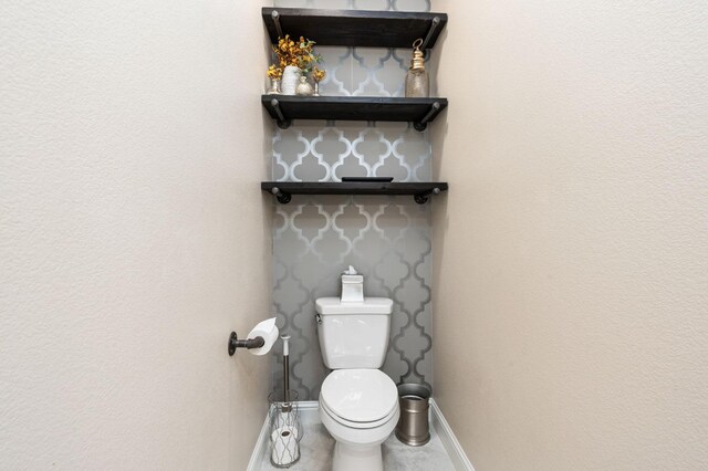 bathroom featuring toilet and baseboards