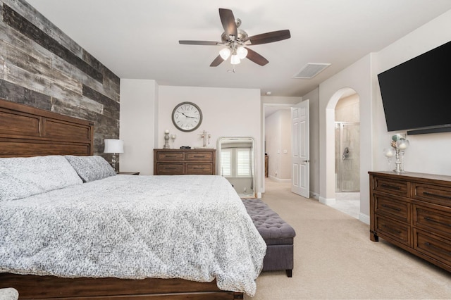 bedroom with arched walkways, light colored carpet, a ceiling fan, baseboards, and visible vents