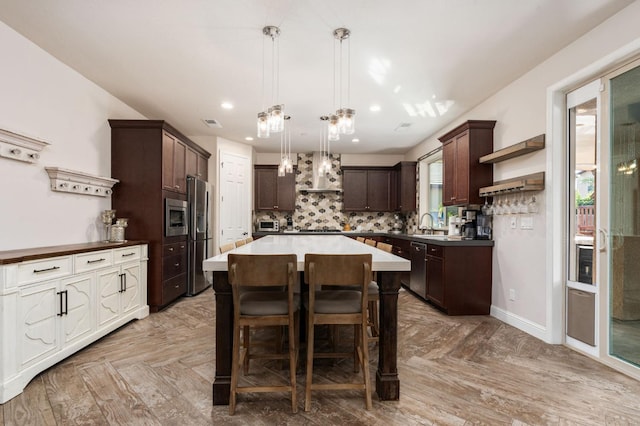 kitchen with a center island, open shelves, stainless steel appliances, backsplash, and dark brown cabinets