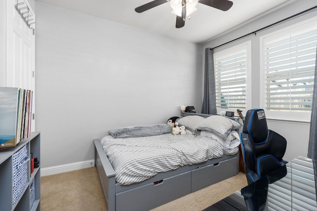 carpeted bedroom with ceiling fan and baseboards