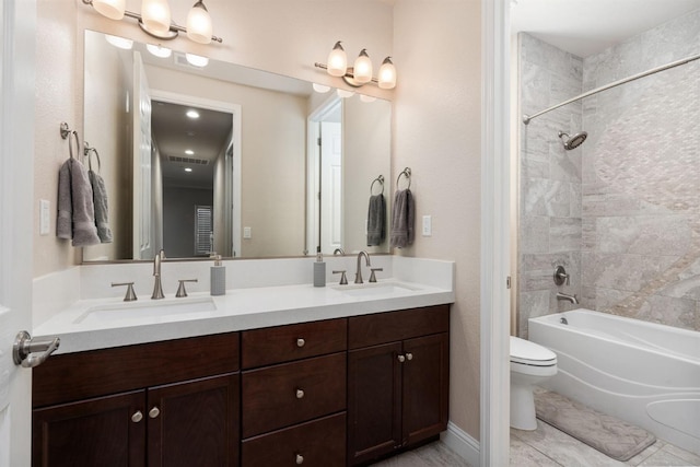 bathroom with double vanity, shower / bath combination, a sink, and toilet