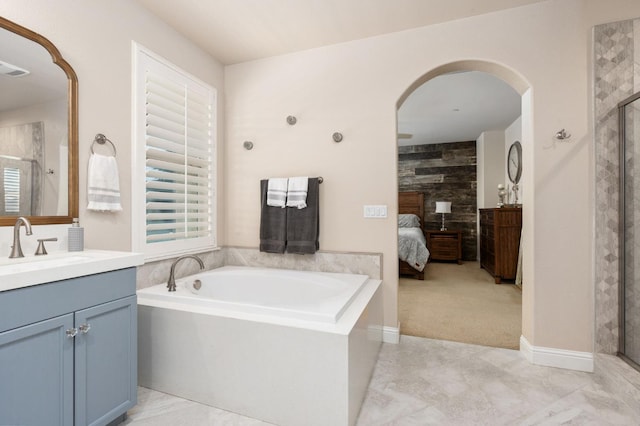 bathroom with a garden tub, a shower stall, vanity, and ensuite bathroom