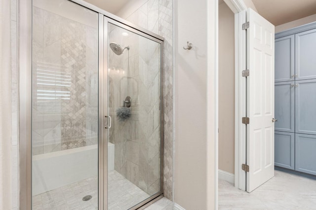 full bath featuring a stall shower and baseboards