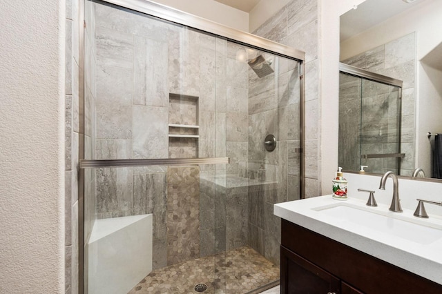 full bathroom with a shower stall and vanity