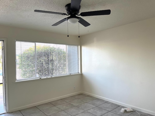 tiled spare room with ceiling fan and a textured ceiling