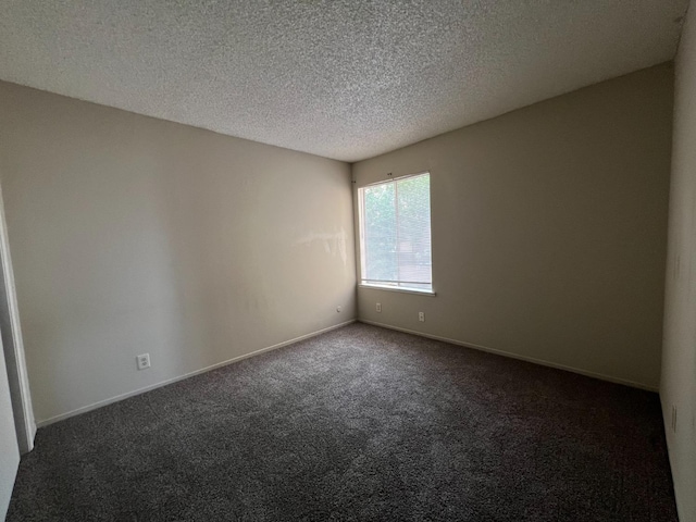 carpeted empty room with a textured ceiling