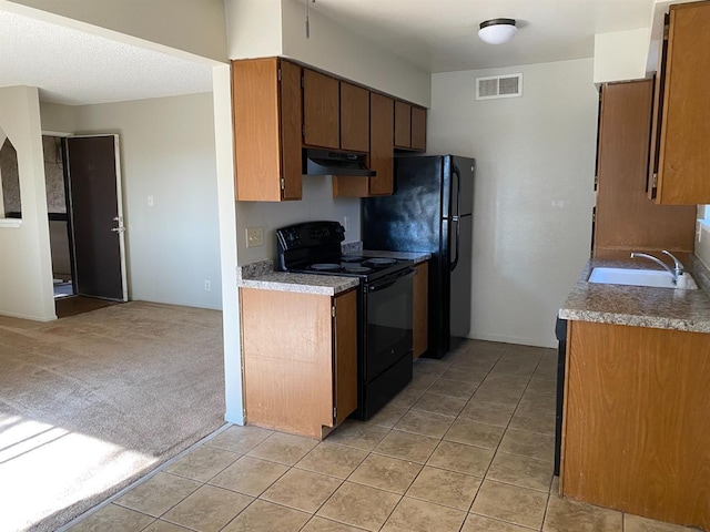 kitchen with black appliances, sink, and light carpet