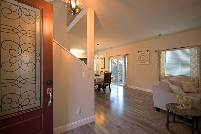 foyer featuring wood-type flooring and an inviting chandelier