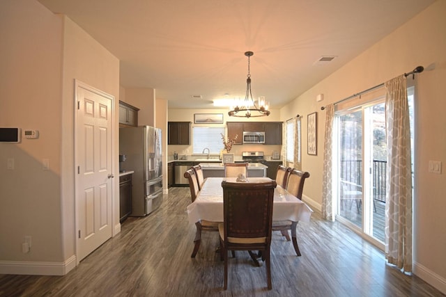 dining room featuring dark hardwood / wood-style flooring, sink, and a chandelier