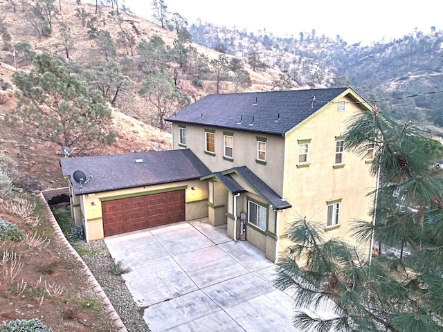 front facade with a mountain view and a garage