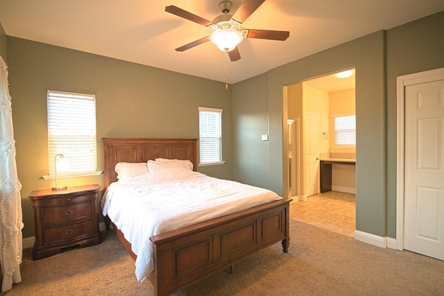 bedroom featuring ensuite bathroom, ceiling fan, and light colored carpet