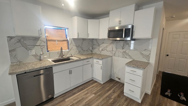 kitchen featuring sink, dark hardwood / wood-style floors, appliances with stainless steel finishes, tasteful backsplash, and white cabinetry