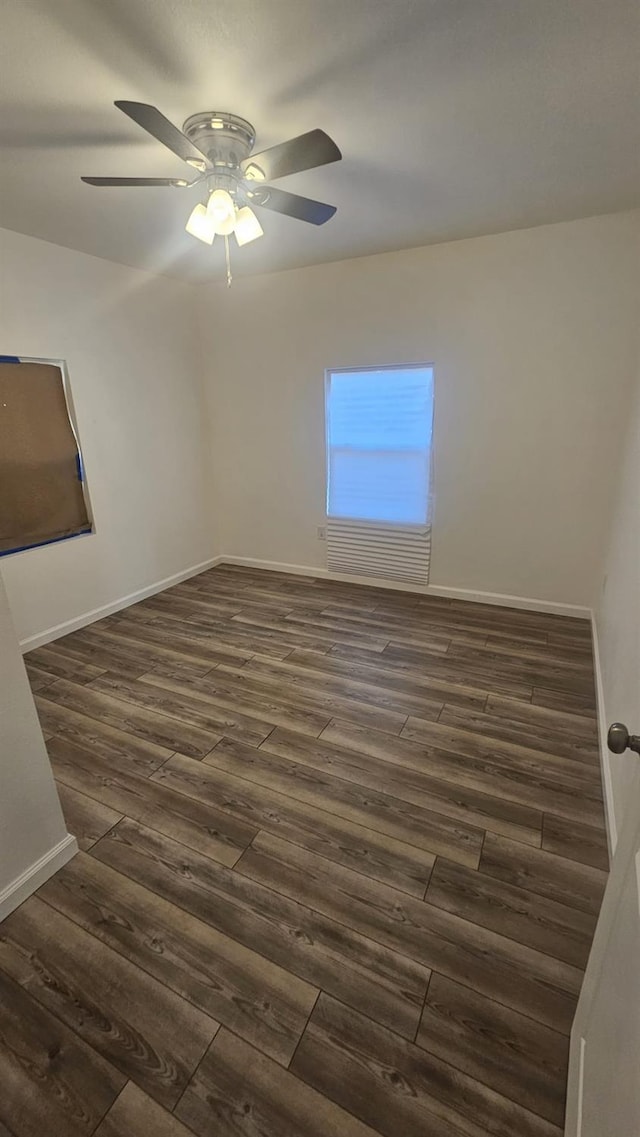 spare room featuring dark hardwood / wood-style flooring and ceiling fan