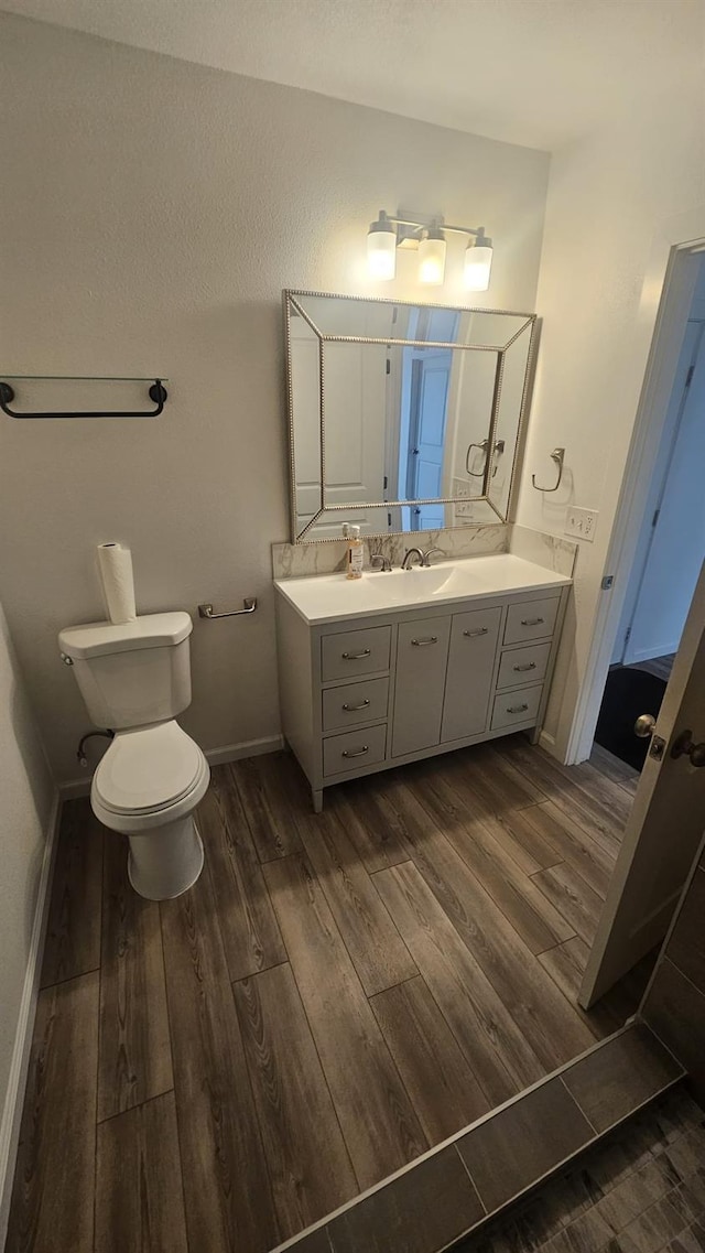 bathroom featuring hardwood / wood-style floors, vanity, and toilet