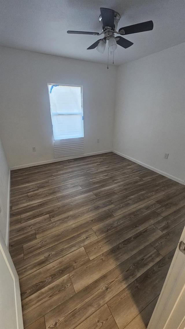 unfurnished room with ceiling fan and dark wood-type flooring