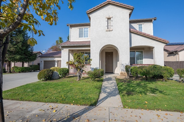 mediterranean / spanish house with a front lawn and a garage