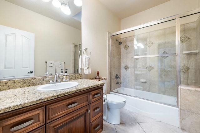 full bathroom with tile patterned floors, shower / bath combination with glass door, vanity, and toilet