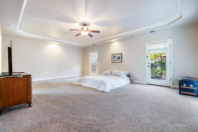 bedroom featuring ceiling fan, access to exterior, light carpet, and a raised ceiling