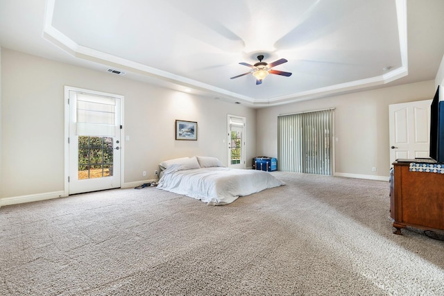 bedroom with ceiling fan, access to exterior, a raised ceiling, and carpet floors