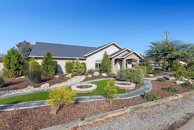 single story home featuring a front lawn and a fire pit