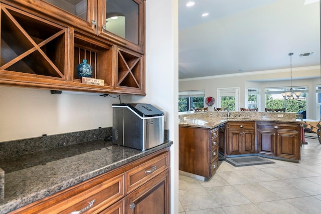 kitchen with dark stone counters, crown molding, a chandelier, and pendant lighting