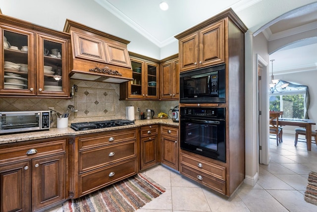 kitchen with black appliances, vaulted ceiling, light stone countertops, and ornamental molding