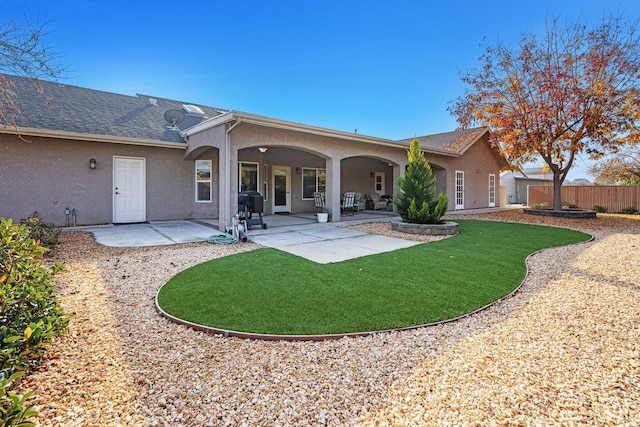 rear view of house with a patio area and a lawn