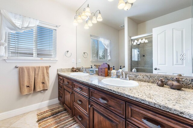 bathroom with a shower with shower door, tile patterned floors, vanity, and a notable chandelier