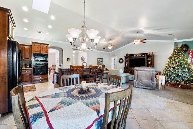 dining area featuring ceiling fan with notable chandelier, light tile patterned floors, lofted ceiling, and ornamental molding