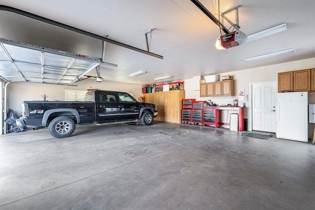 garage featuring a garage door opener and white fridge