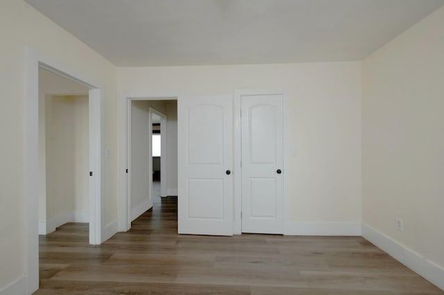 unfurnished bedroom with a closet and light hardwood / wood-style flooring