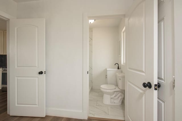 bathroom with hardwood / wood-style flooring and toilet