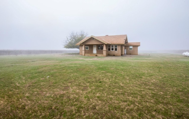 view of front facade featuring a front yard and a rural view