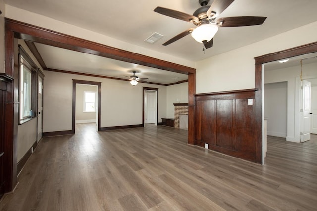 unfurnished living room with ceiling fan, dark hardwood / wood-style flooring, and ornamental molding