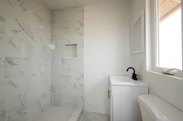 bathroom featuring vanity, toilet, and tiled shower