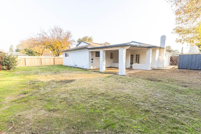 rear view of house featuring a lawn